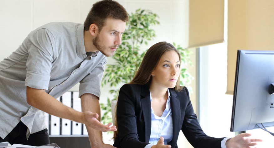 Upset businesspeople trying to work on line with a desktop computer looking at monitor at office